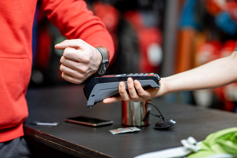 person paying at till with watch